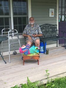 Jim sitting on the front porch at Grand Isle art works